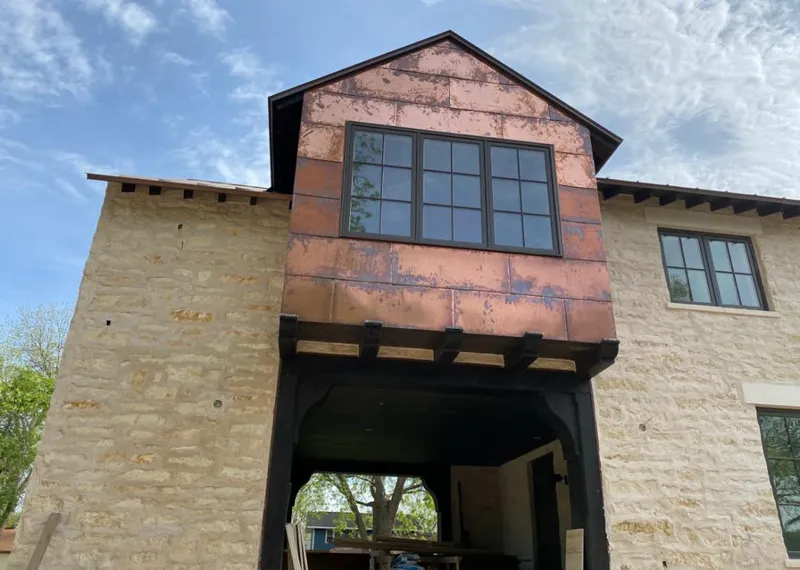 Copper metal panel facade on a stone building for Metal Roof Coating in Pearl